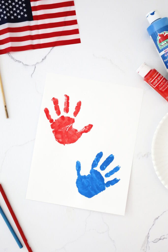 Red and white handprints on a piece of white paper.