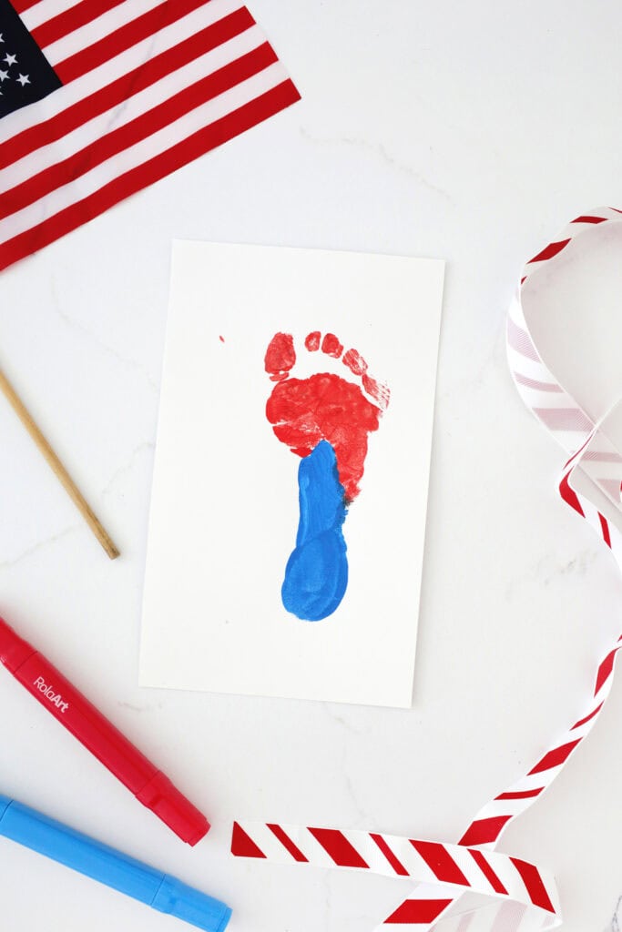 Painted footprint on a piece of paper in red and blue paint.