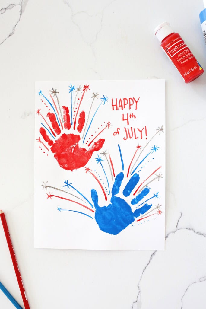 Red and white handprints on a piece of white paper made to look like fireworks.