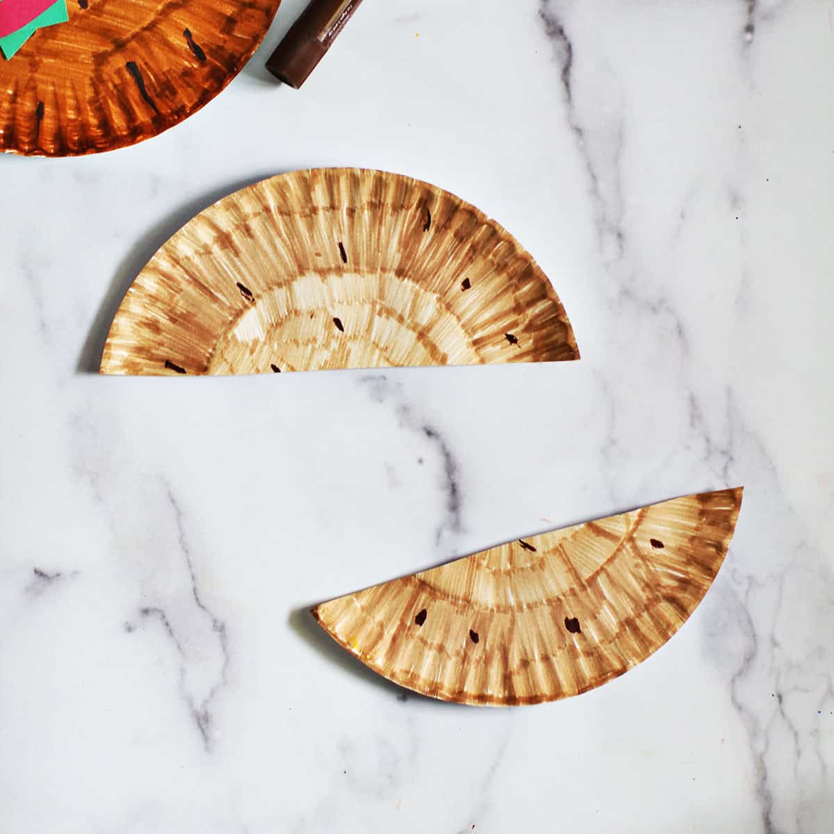 Paper plate that's been colored tan and cut in half to look like a hamburger bun.