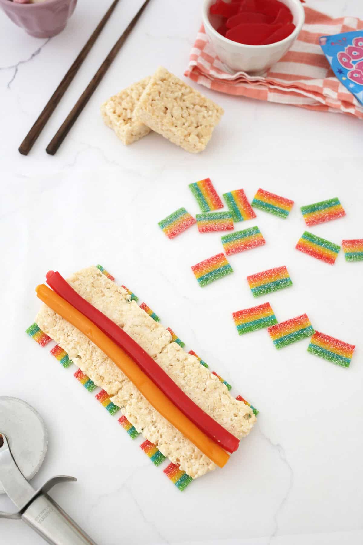 jolly rancher ropes being added on top of rice kripsies and airheads to make a candy sushi roll.