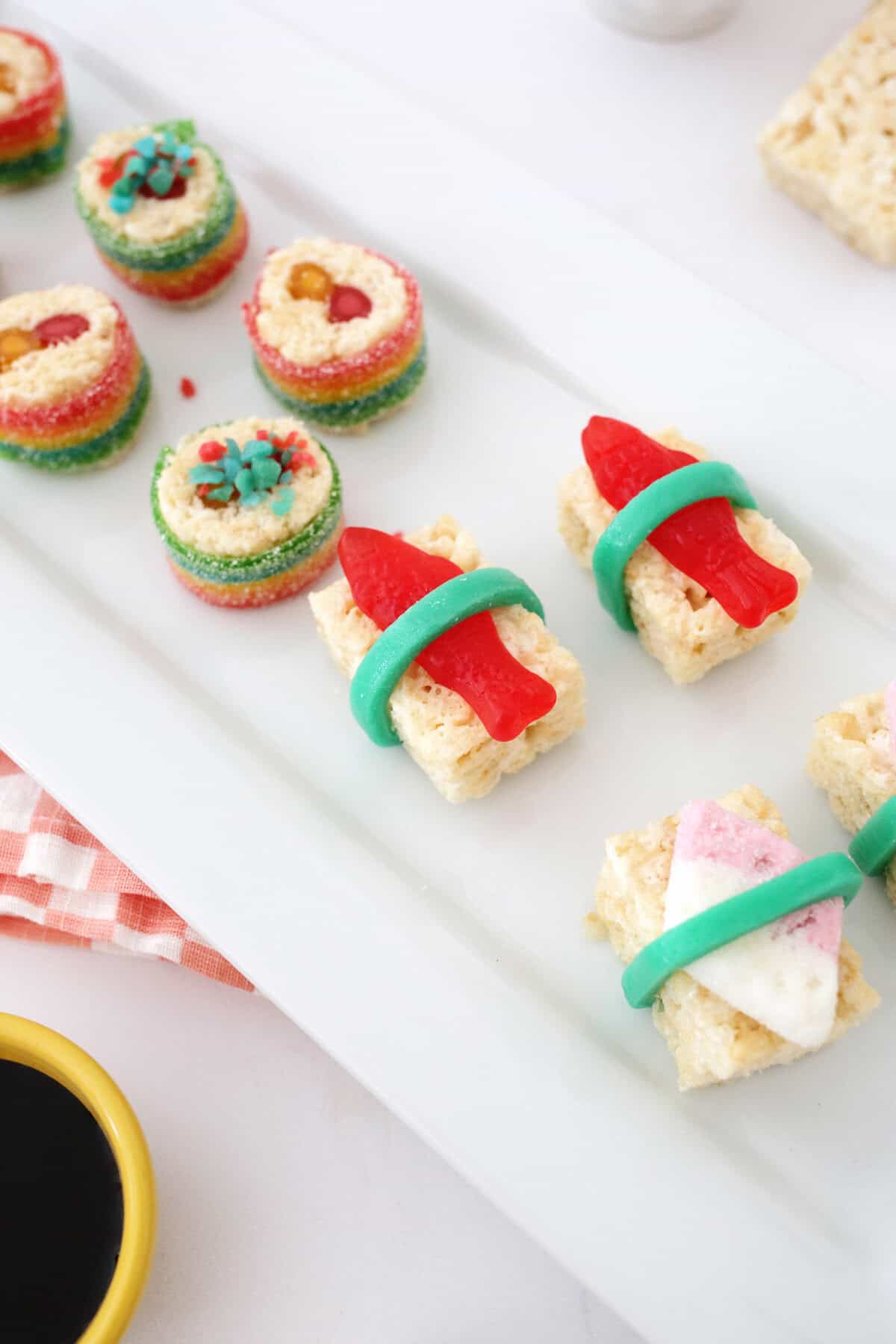 candies made to look like sushi pieces sitting on a white plate.