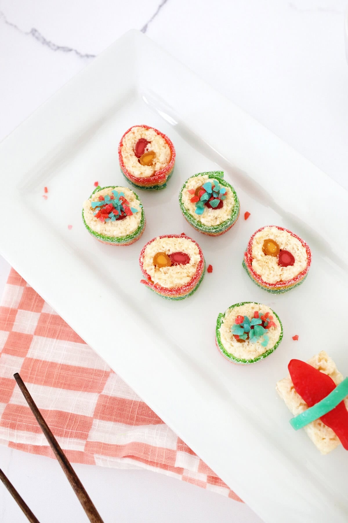 sushi candy rolls on a white plate.