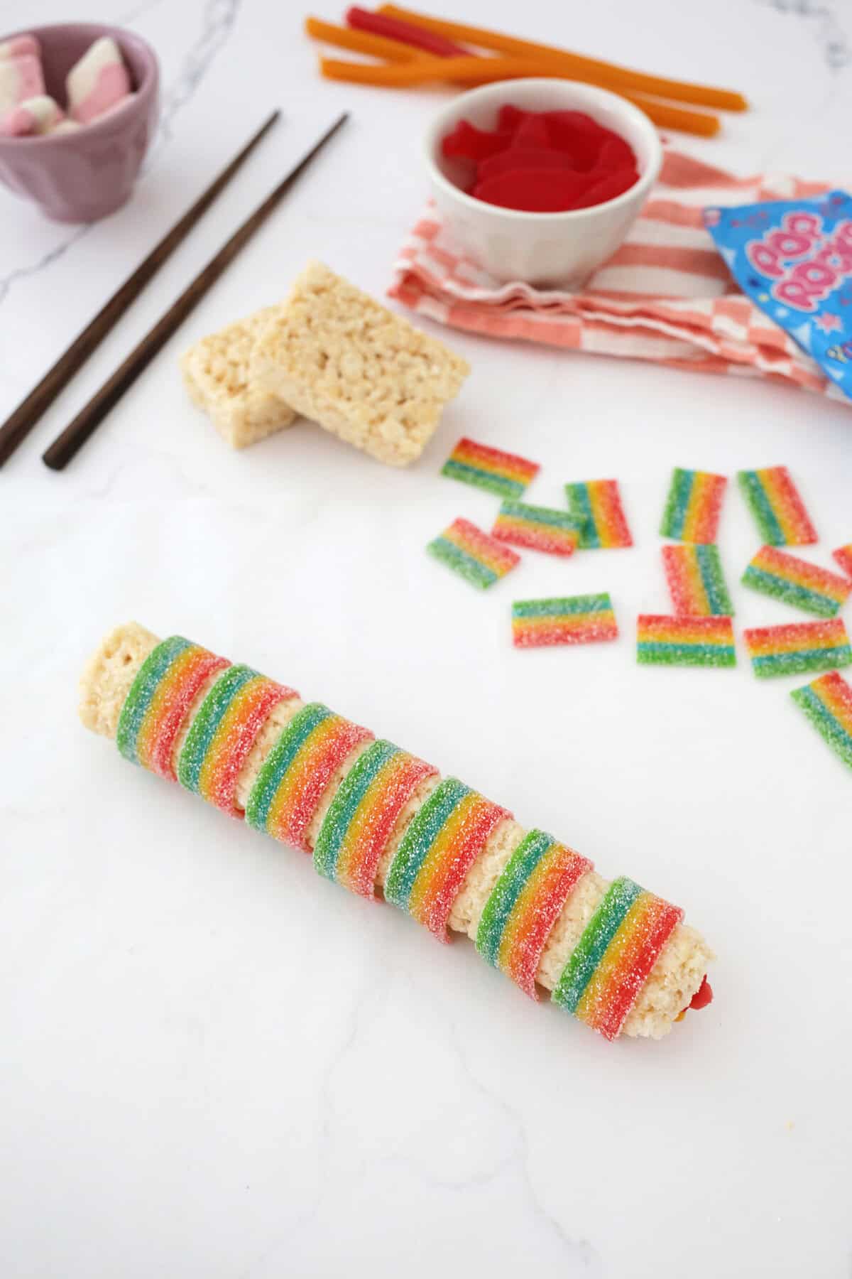 candy sushi being made by rolling candy inside a rice krispie treat that's wrapped with an airhead extreme.
