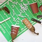 pom pom shooters made with brown cups and brown balloons to look like footballs on a football field placemat.