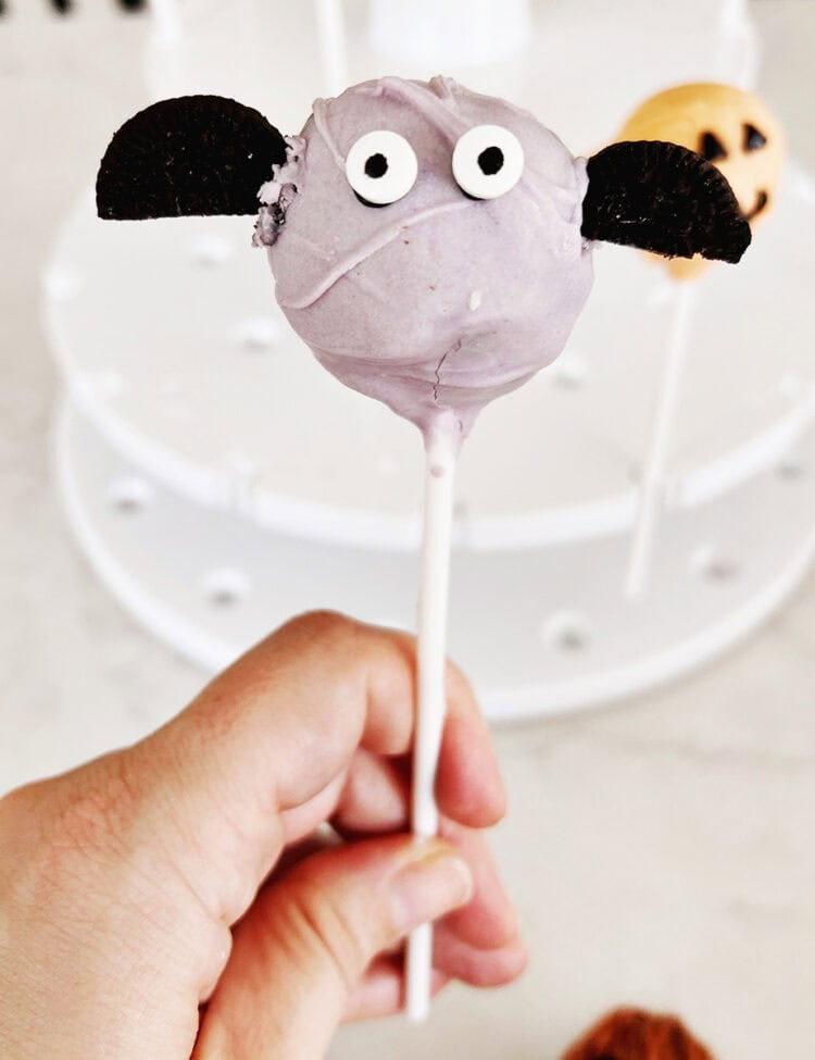 Purple cake pop decorated with googley eyes and oreos to look like a bat.