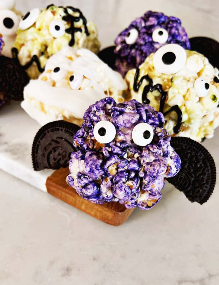 Halloween themed popcorn balls on a tray.